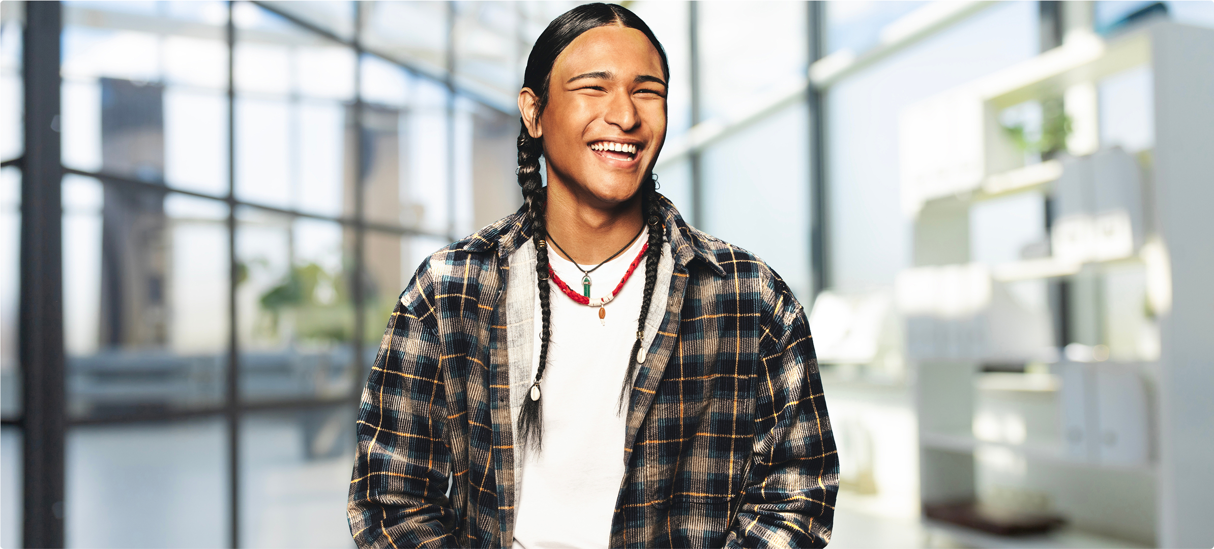 Young Indigenous man, sitting and smiling.